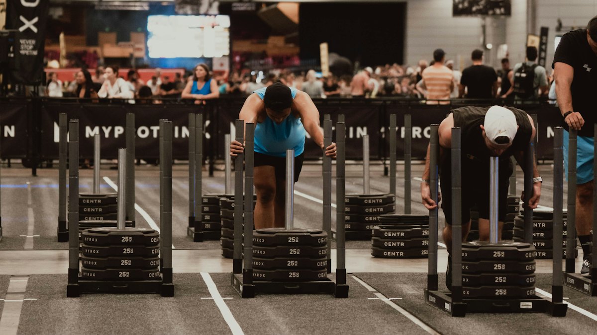 Athletes training with weighted sleds inside an indoor gym