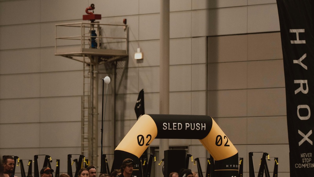 HYROX sled push station at an indoor fitness race