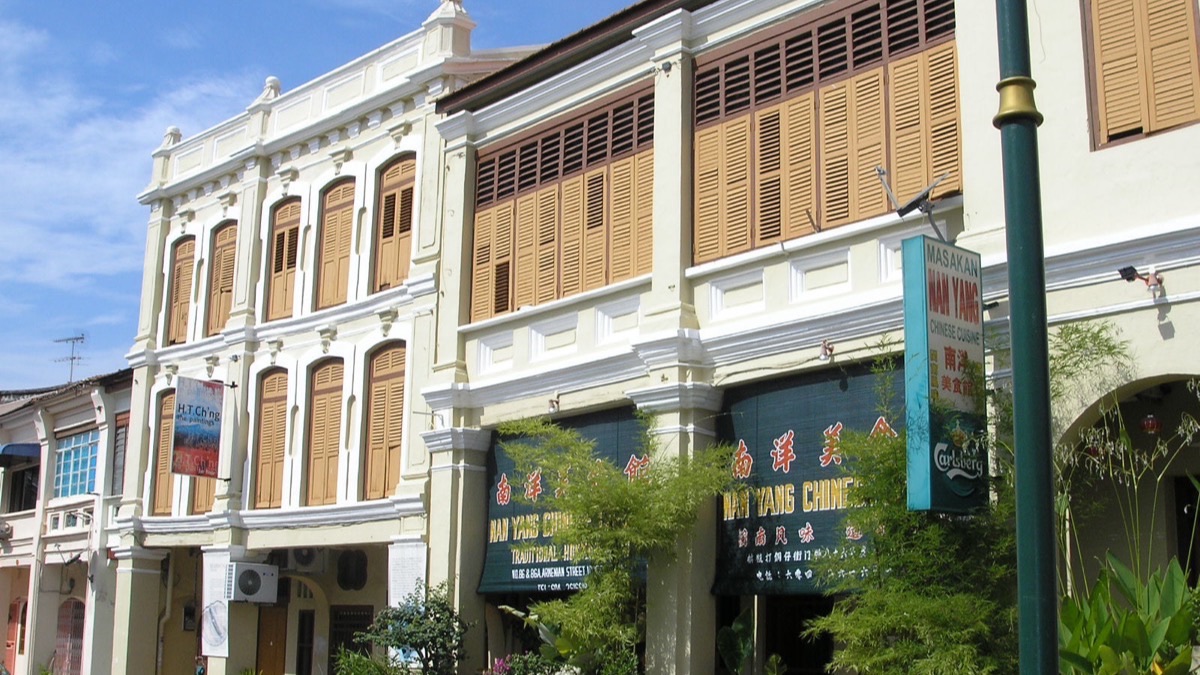 Restored heritage shophouses with wooden shutters in George Town, Penang